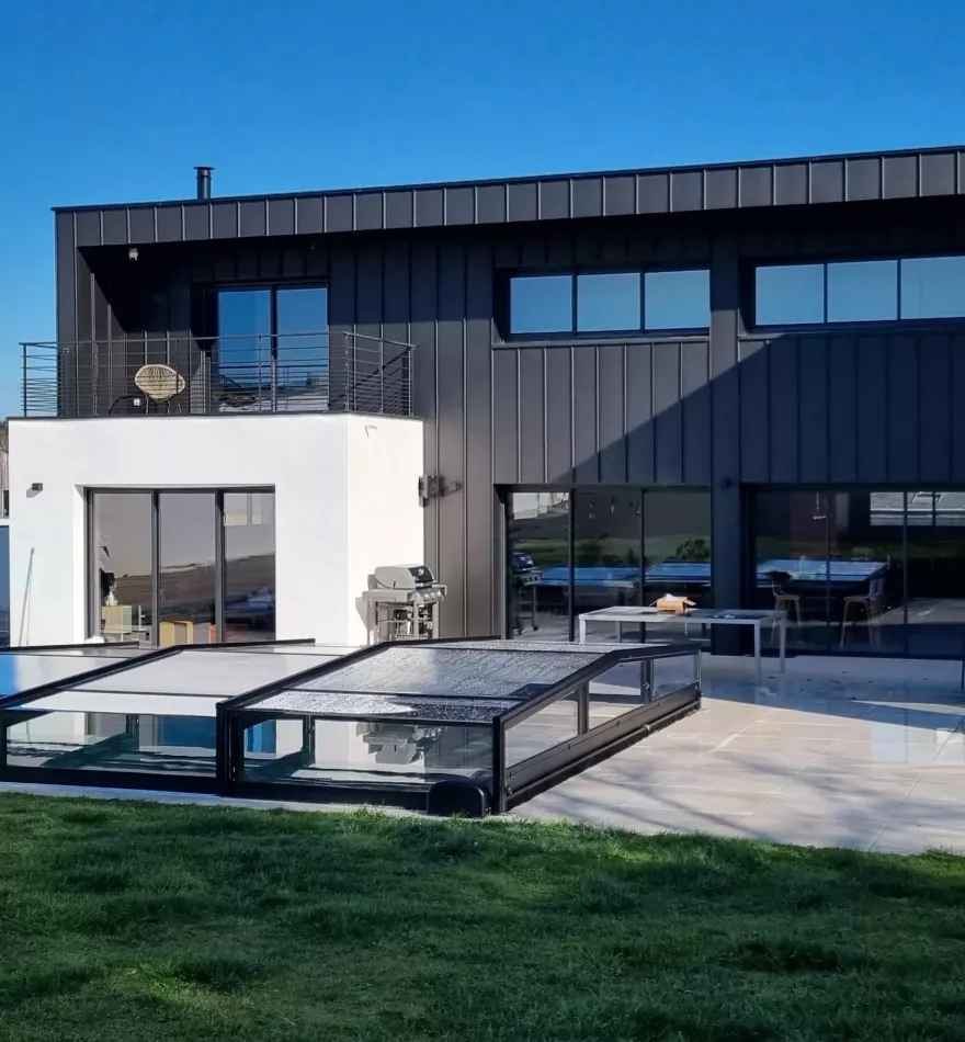 Piscine extérieure avec abri rigide, jardin bien entretenu et maison contemporaine