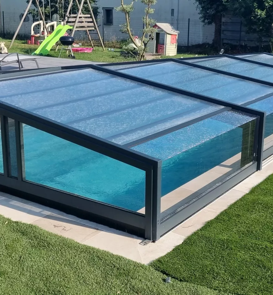 Vue de la piscine avec abri de protection, espace extérieur aménagé autour